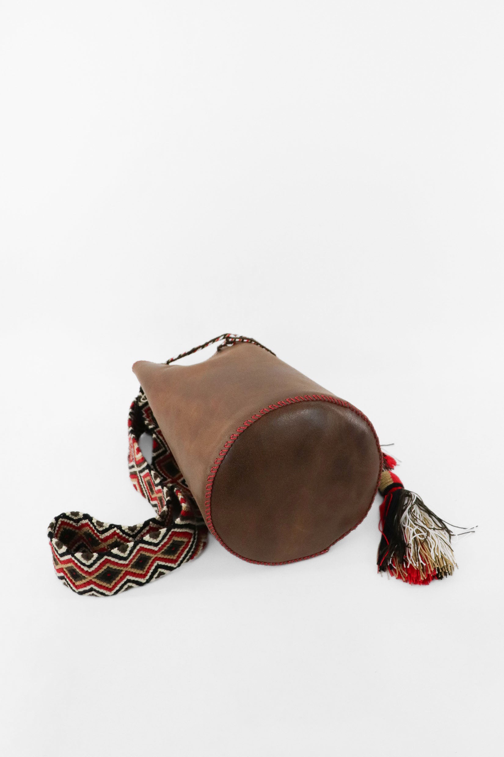 Detalle de la base del bolso bucket marrón con detalles rojos Joaquina Cayetana