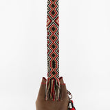 Detalle del lado izquierdo del bolso bucket marrón con detalles rojos Joaquina Cayetana