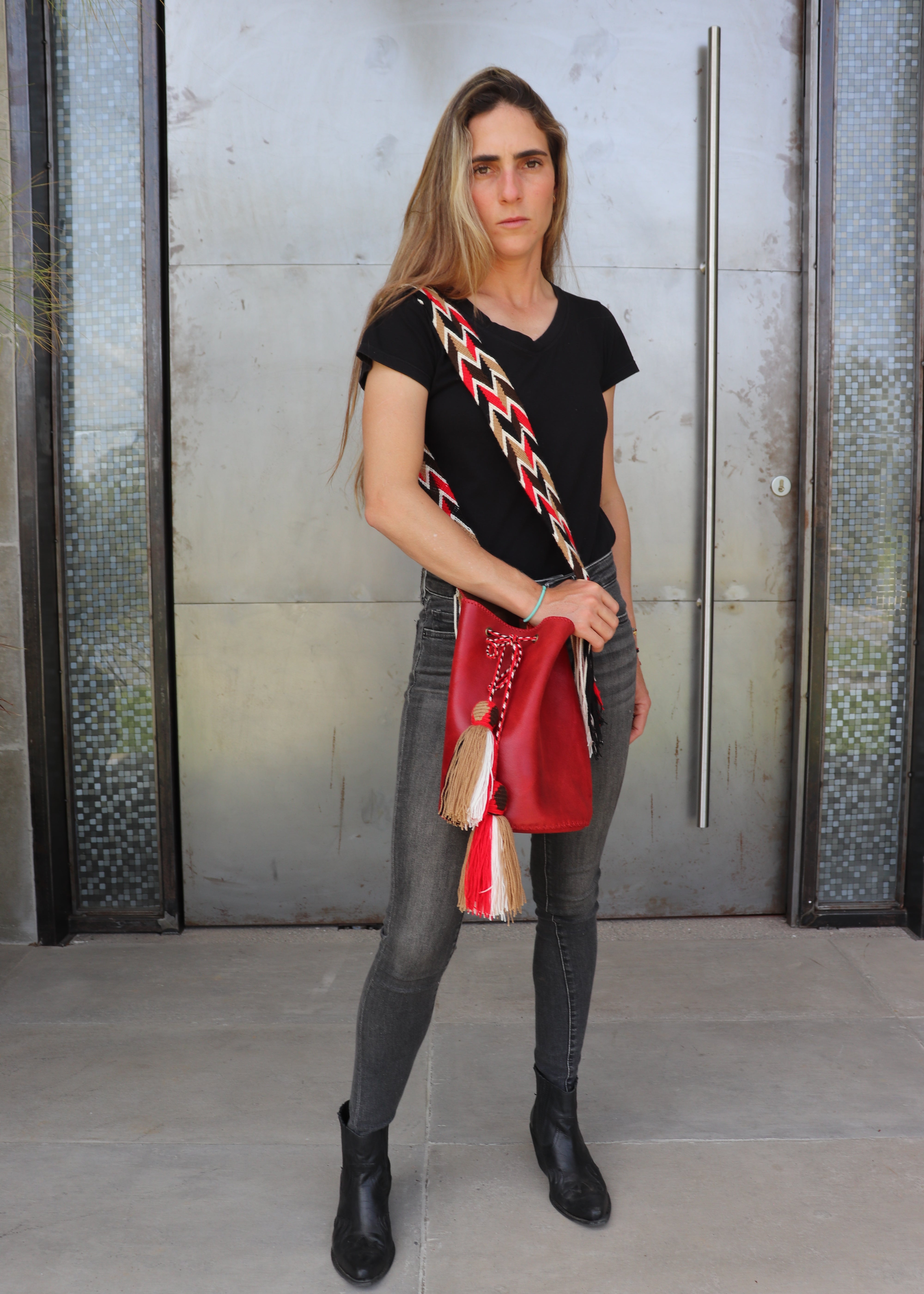 Detalle del bolso rojo APUNU con borlas y correa tejida Wayuu