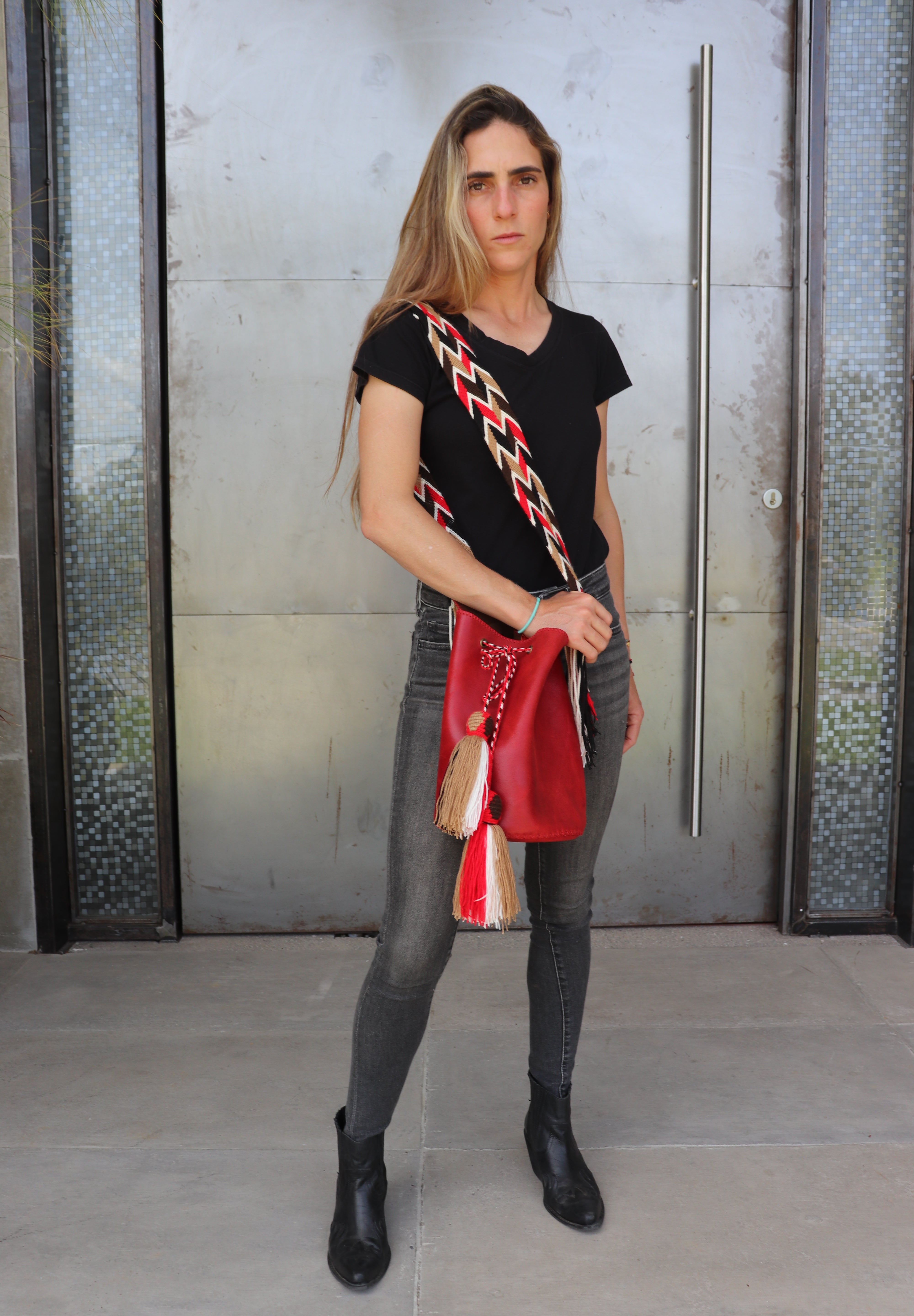 Detalle del bolso rojo APUNU con borlas y correa tejida Wayuu