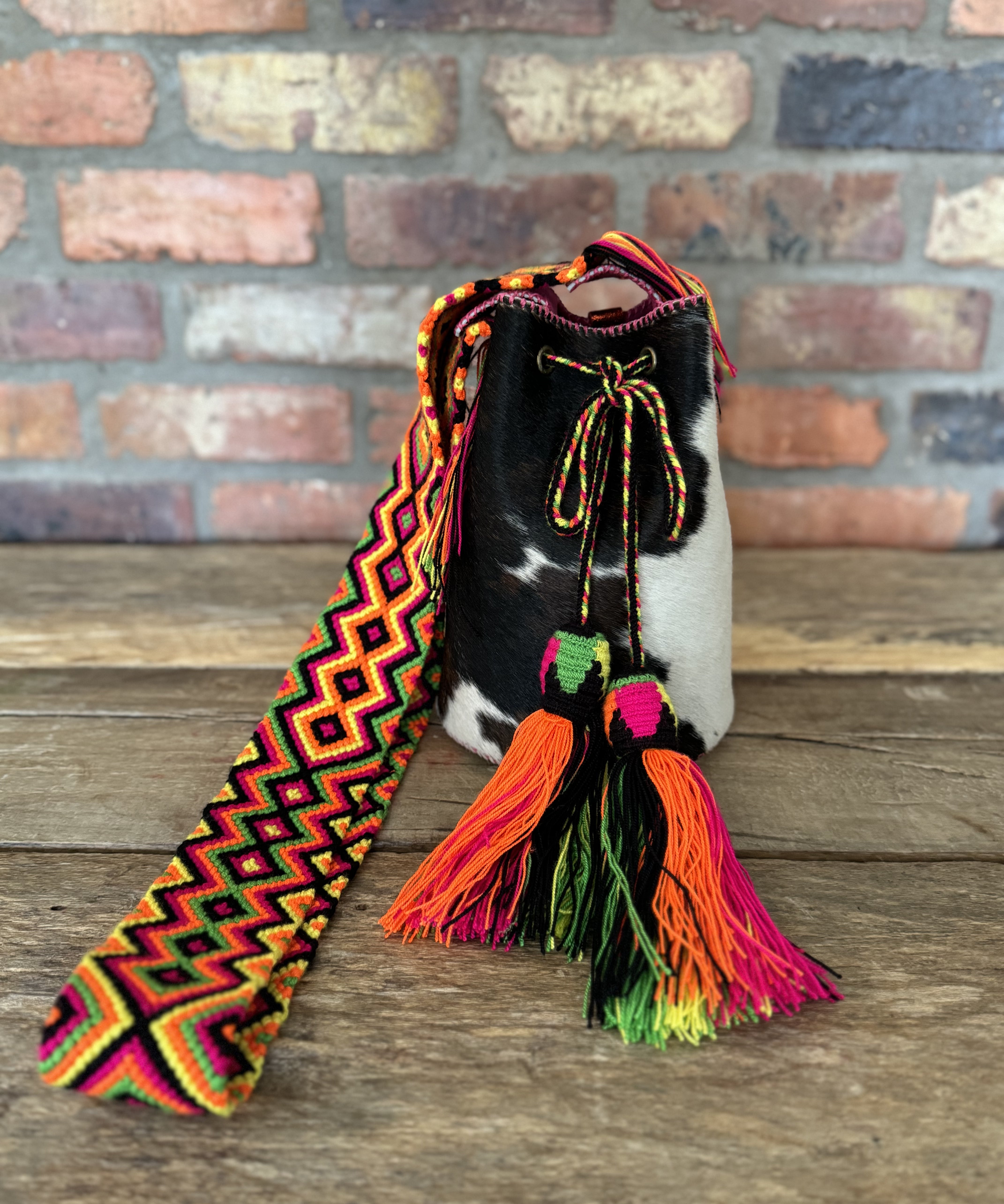 Bolso pequeño bucket estampado de vaca y cuero fucsia hecho a mano Joaquina Cayetana