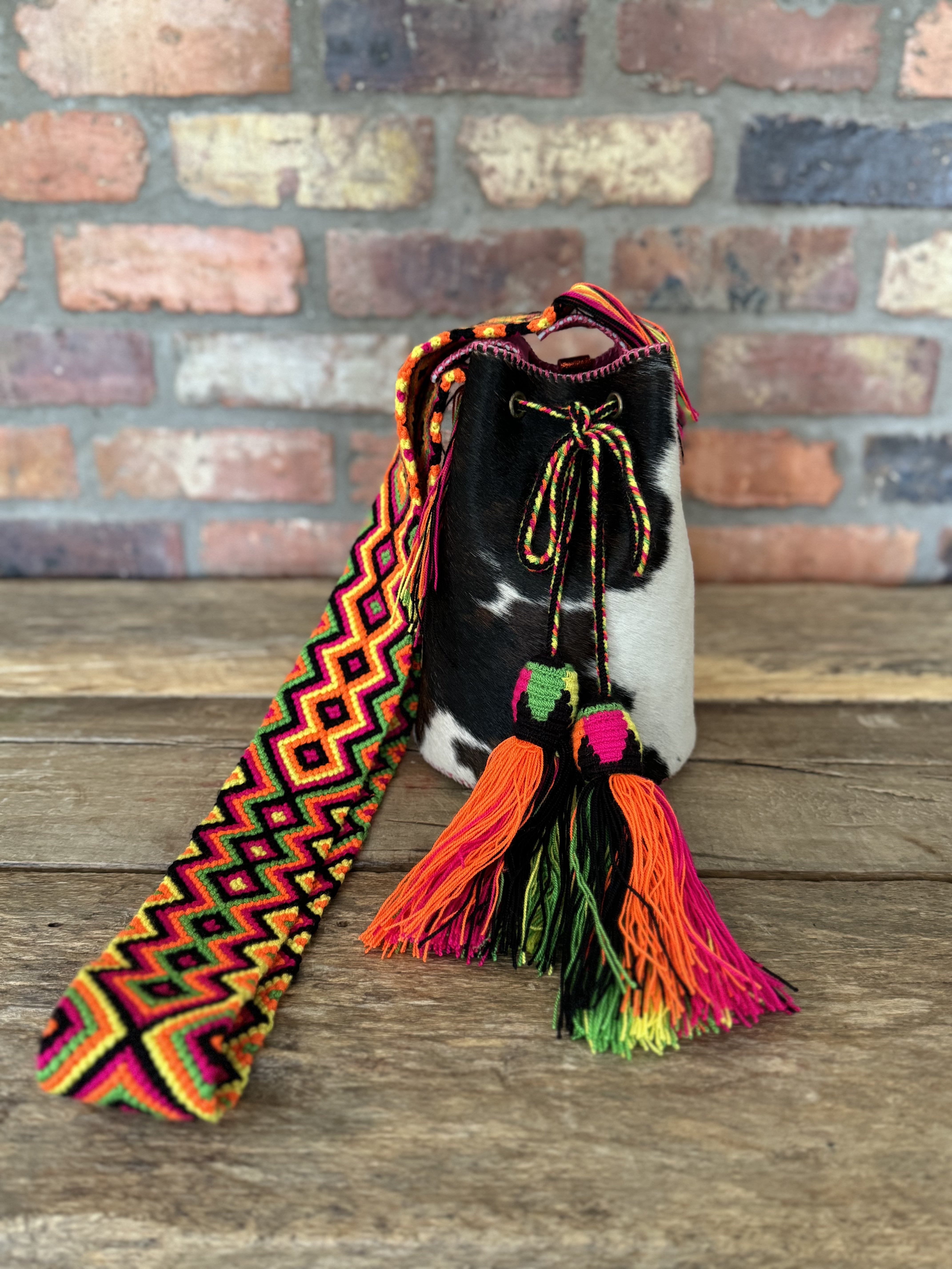 Bolso pequeño bucket estampado de vaca y cuero fucsia hecho a mano Joaquina Cayetana