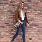 Detalle del bolso APUNU cow print y naranja naranja con correa tejida Wayuu