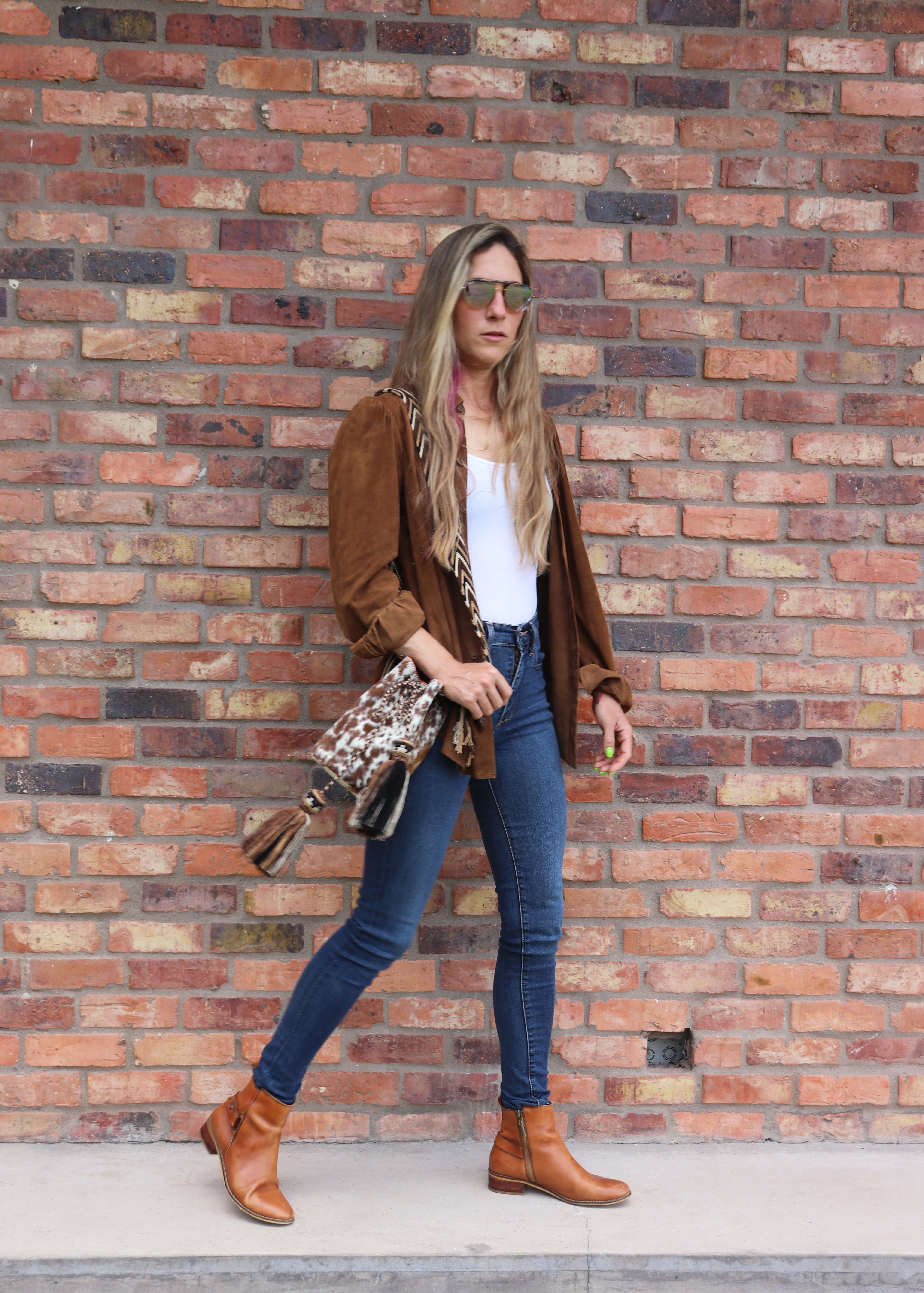 Detalle del bolso APUNU cow print y naranja naranja con correa tejida Wayuu