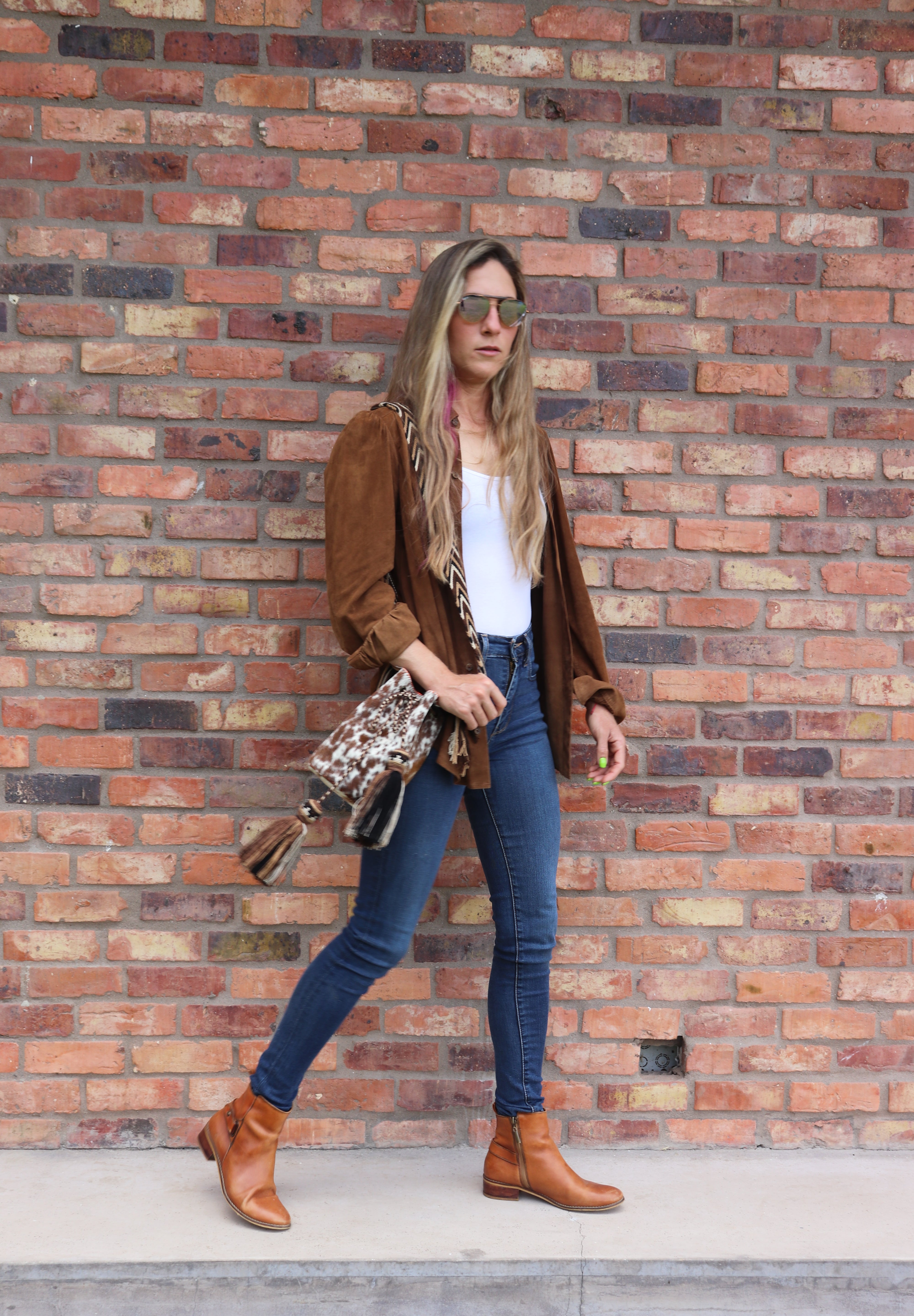 Detalle del bolso APUNU cow print y naranja naranja con correa tejida Wayuu